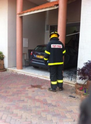 צופה אש על רקע רכב שנכנס בבניין